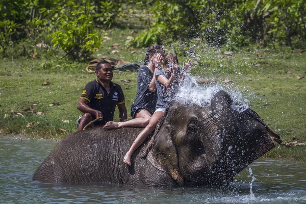 Dos chicas turísticas jóvenes jugando con elefante asiático en Nepal —  Fotos de Stock