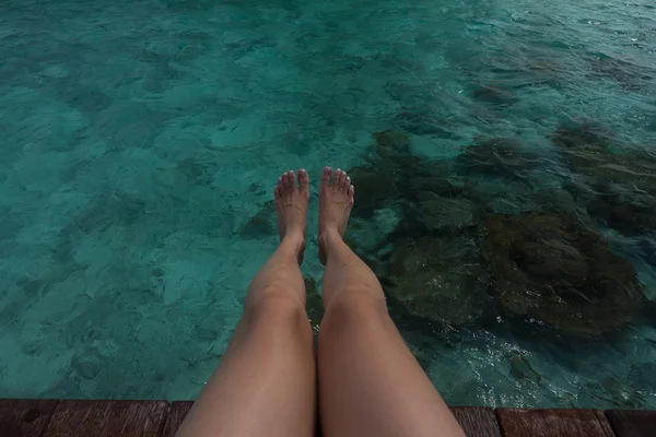 여자의 다리 위에 매달려 맑은 바닷물 — 스톡 사진