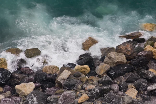 在 Vernazza，五渔村的多彩石滩上的海浪 — 图库照片