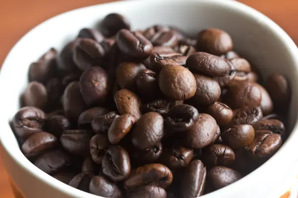 Granos de café colocados en una taza —  Fotos de Stock