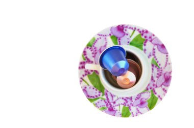 Overhead view of coffee cup filled with coffee capsules isolated on white clipart