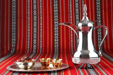 Iconic Abrian fabric with Arabic tea and dates symbolise Arabian hospitality clipart