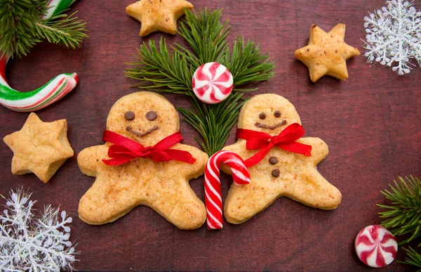 Weihnachten Hintergrund mit Lebkuchen, Bonbons, Tannenzweige auf dem alten Holzbrett — Stockfoto