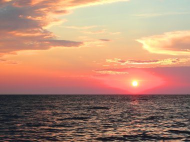 Denizin üzerinde gün batımı.