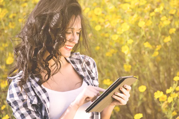 Sending email with a tablet among flowers — Stock Photo, Image