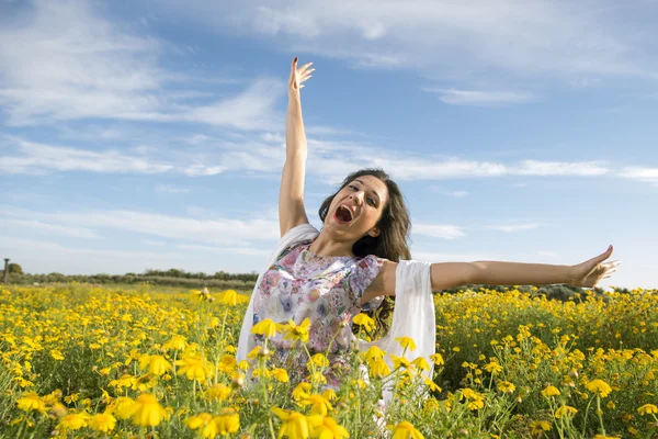 Gelukkig jongedame permanent in de gele daises veld — Stockfoto