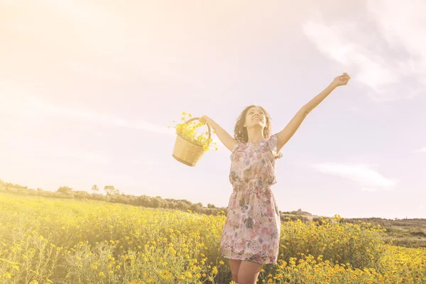 Girl dancing among flowers in a sunny day — Stock Photo, Image