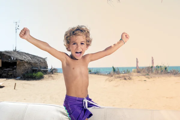 Çocuk sahilde mutlu bağırır