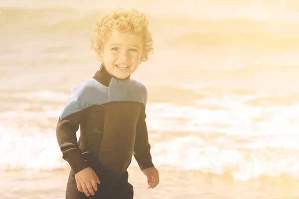 Verspielter Junge am Strand mit Meer im Hintergrund — Stockfoto