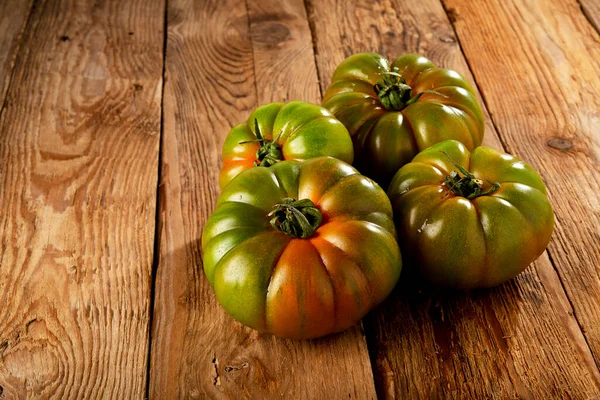 乡村木板上的绿色带肋西红柿 — 图库照片