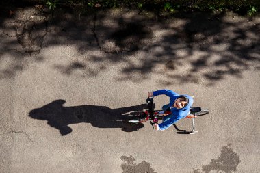 Çocuk bisiklet sürerken yol manzaralı şehir manzarasının tadını çıkar ve gülümse.