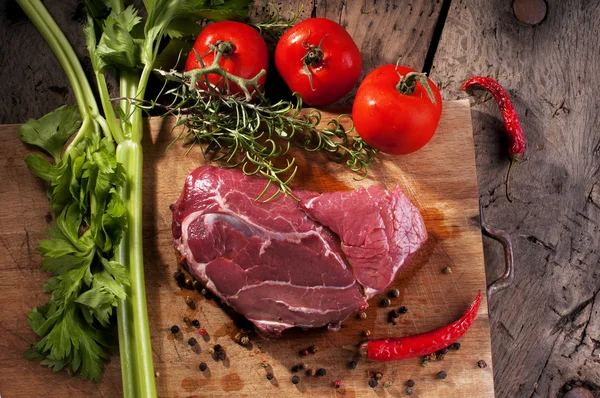 Bistecca di manzo cruda su un tavolo di legno — Foto Stock