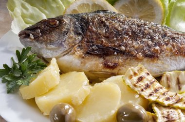 patates ve limon ile süslenmiş çipura balığı