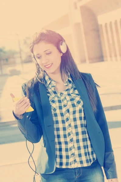 女の子彼のスマート フォンから音楽を聴いて適用フィルター instagr — ストック写真