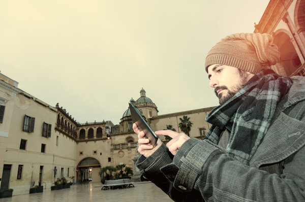 Young Man reading a tablet in instagram toned style