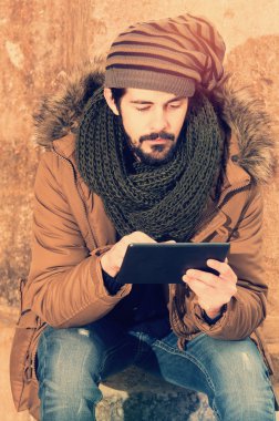 şık hipster adam oturma kullanarak tablet ile bir sıcak sesi filtre