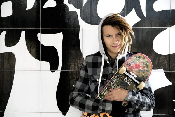 Retrato de jovem com skate e cabelo rasta — Fotografia de Stock