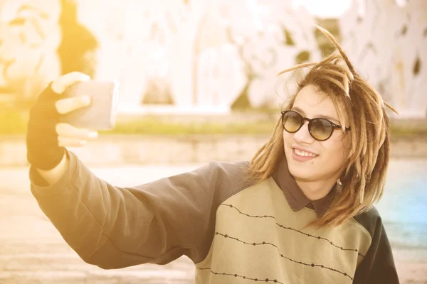 若いラスター男屋外撮影 wa を持つスマート フォンと selfie — ストック写真