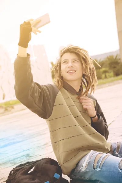スマート フォンのウィットと selfie に笑みを浮かべて屋外ラスター若者 — ストック写真