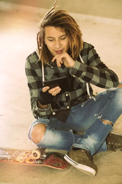 Freelance dreadlocks cara sentado com tablet digital filte quente Imagens De Bancos De Imagens