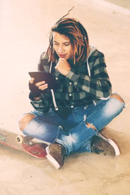 Dijital tablet sıcak filtresi uygulanmış oturan dreadlocks adam