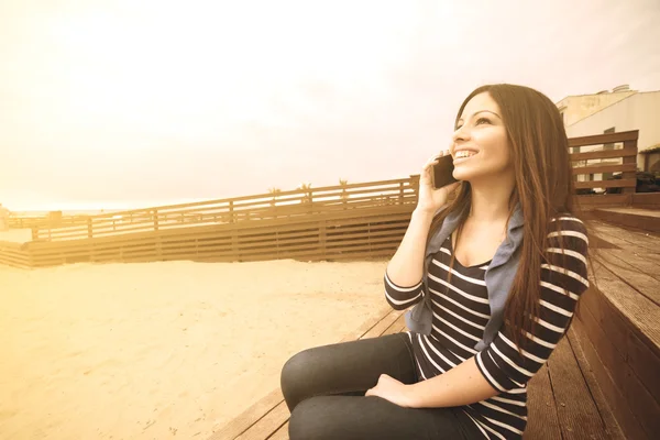 Lachen meisje pratende telefoon warm filter toegepast — Stockfoto