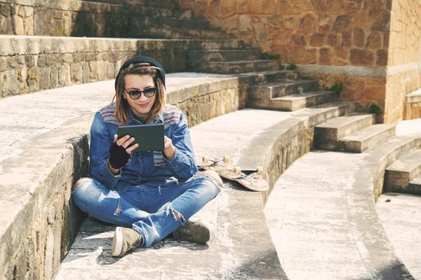 Sitting on a staircase with tablet warm filter applied — Stock Photo, Image