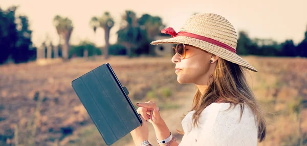 Girl writing on ltablet in countryside — Stock Photo, Image