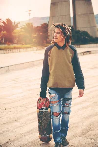 Facet moda młody hipster i jego skateboard — Zdjęcie stockowe