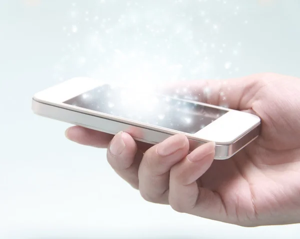 Beyaz smartphone üzerinde ışık arka plan izole el ile. — Stok fotoğraf