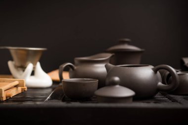 Çay partisi için koyu bir arka planda Asya mutfak gereçleri. Tören, süreç, çaydanlık, fincan, kil, gelenek.