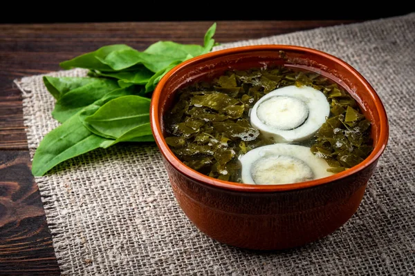 Sorrel soup on dark wooden background. — Stock Image Sorrel soup on dark wooden background. Royalty Free Stock Images