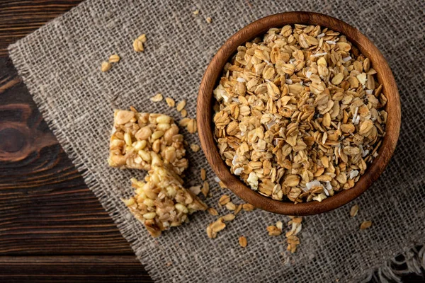 Granola and granola bar on dark wooden background. — Stock Photo, Image