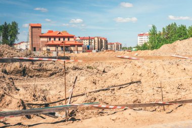 Endüstriyel vinçler, bitmemiş yüksek binalar ve arka planda mavi gökyüzü. Beyaz Rusya.
