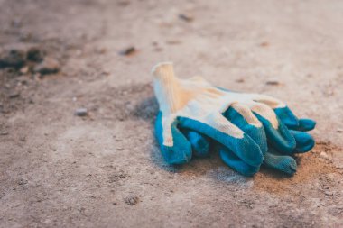 Mavi inşaat eldivenleri ve mala.