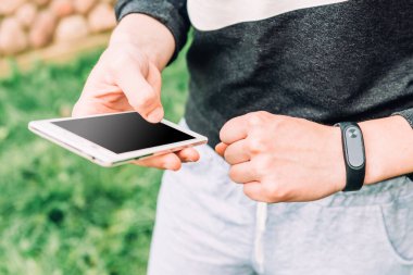 El bileziği ve arka planda cep telefonu.