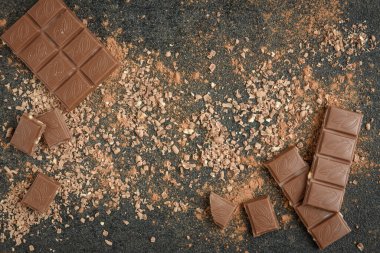 Sütlü çikolata parçacıkları ve siyah arka planda kakao.