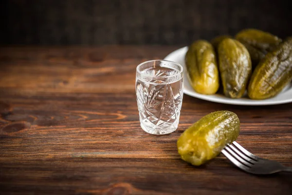 Gekneusde Komkommers Een Wit Bord Wodka Een Rustieke Houten Tafel — Stockfoto