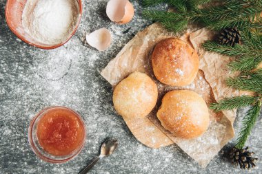 Elma reçelli ev yapımı Noel çörekleri ve gri arka planda köknar dalları.