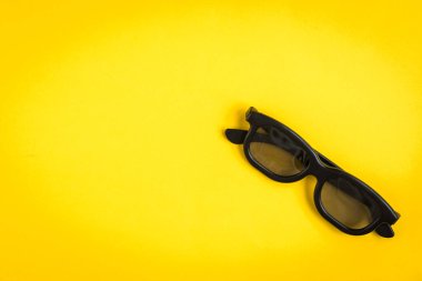 Sarı arka planda TV uzaktan kumandalı 3D gözlükler.