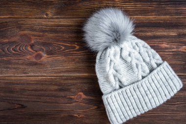 Gri kış örgü şapkası ve tahta arka planda patlama..