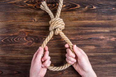 Ahşap arka planda ip. - İntihar. Çalıştırılan düğüm.