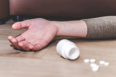 Uyuşturucu ya da zehir hapları konsepti. Elini yere koy, haplar. Aşırı dozda ilaç ve bağımlılıkla intihar..