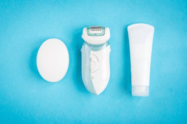 Mavi arka planda sabun, krem ve tüy dökücü. Banyo ürünleri. Temizleme ve cilt bakımı.