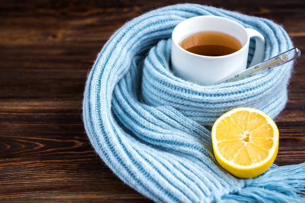 木製の背景に温度計 青いスカーフとレモンティーカップ インフルエンザの季節病 — ストック写真