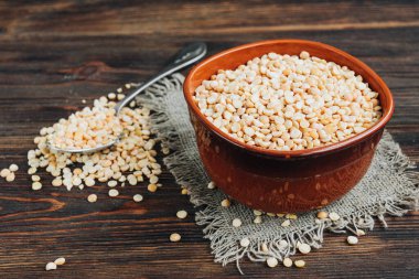 Ahşap arka planda kahverengi kâseye bezelyeleri ayır..