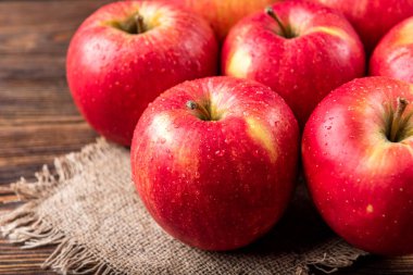 Koyu tahta arka planda kırmızı elmalar.