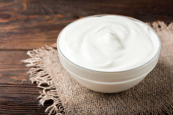 Сметана на темном деревянном фоне.