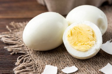 Koyu ahşap arka planda haşlanmış yumurta..