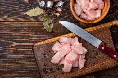 Koyu ahşap arka planda kesilmiş çiğ tavuk göğsü ya da fileto..